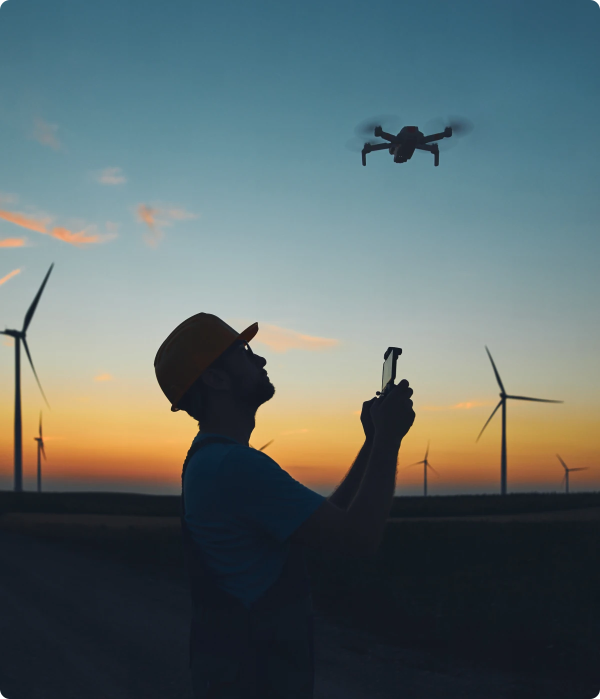 Person controlling drone in evening sky